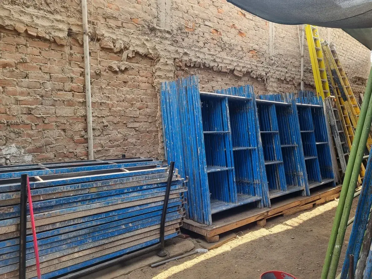 Marcos de andamios azules y escaleras almacenados